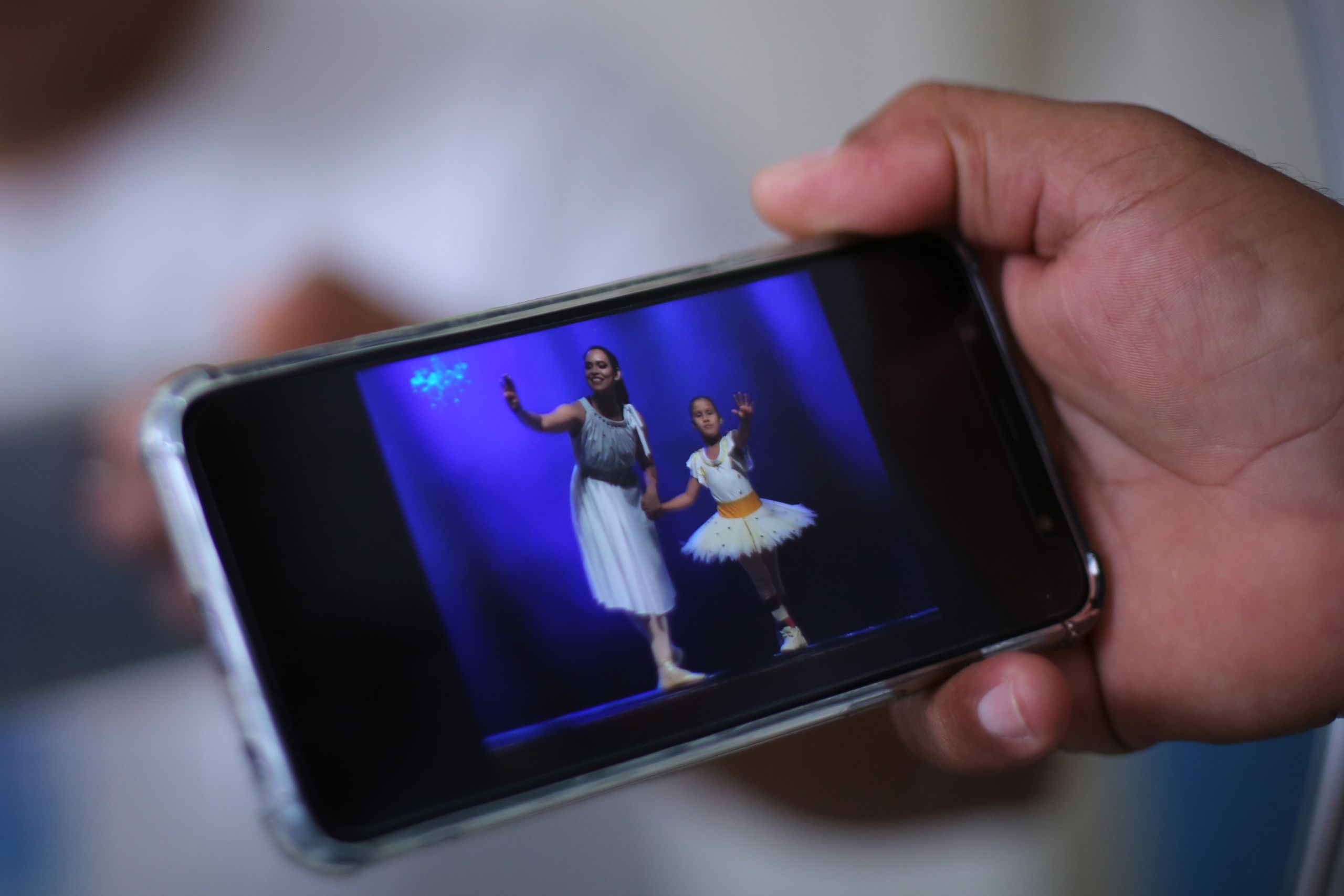 Stolz zeigt der Vater Bilder seiner Tochter auf dem Display seines Smartphones. Emanuelly in Ballettkleidern, mit Schienen an den Beinen, damit sie sich die Knöchel nicht bricht, die sie nicht spürt.