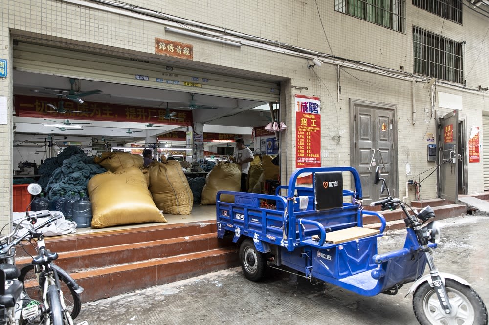 L'entrée de l'atelier, encombré de sacs de vêtements.