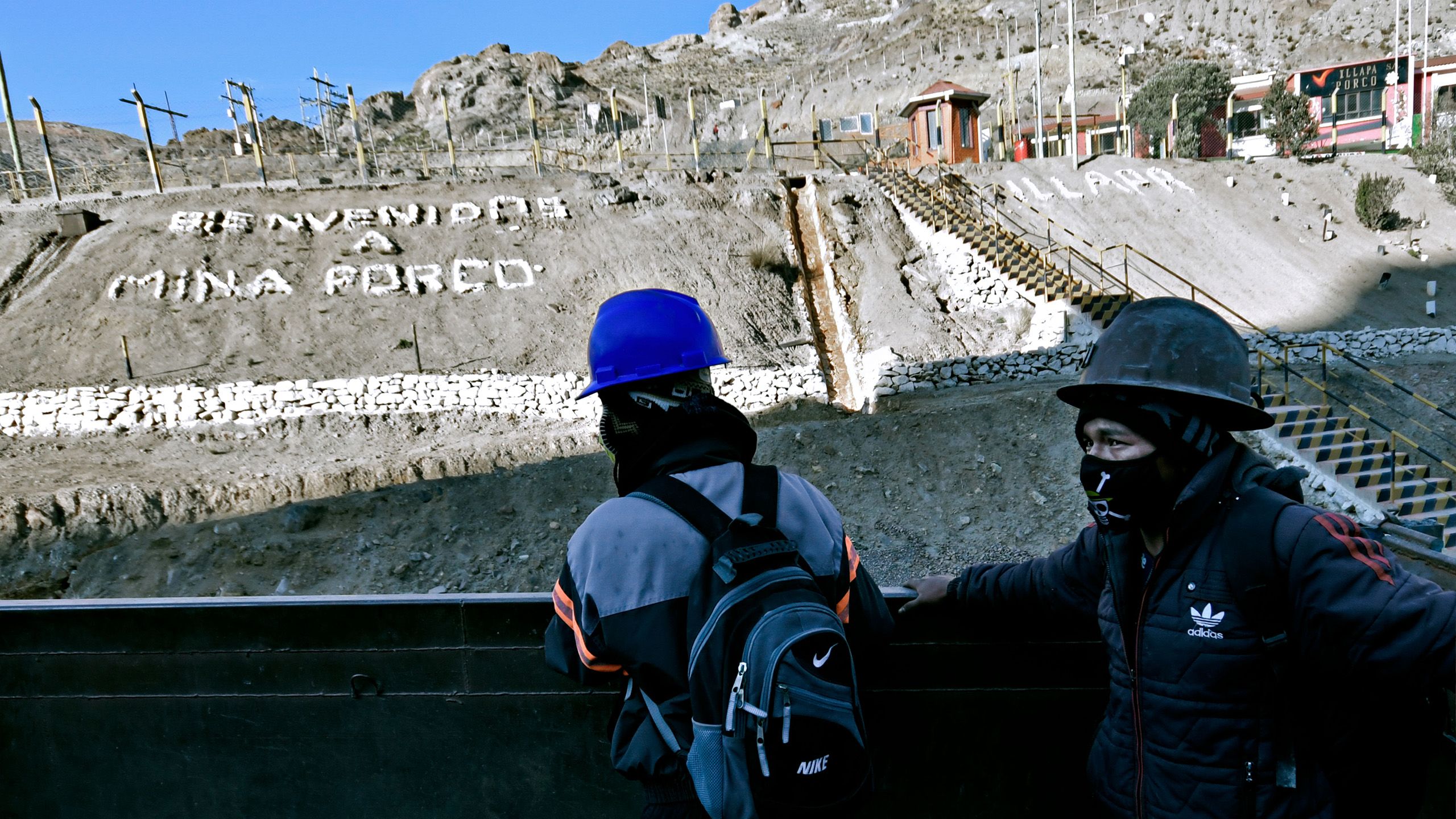 Miners in front of an inscription "Bienvenidos Mina Porco", "Welcome to the Porco Mine"