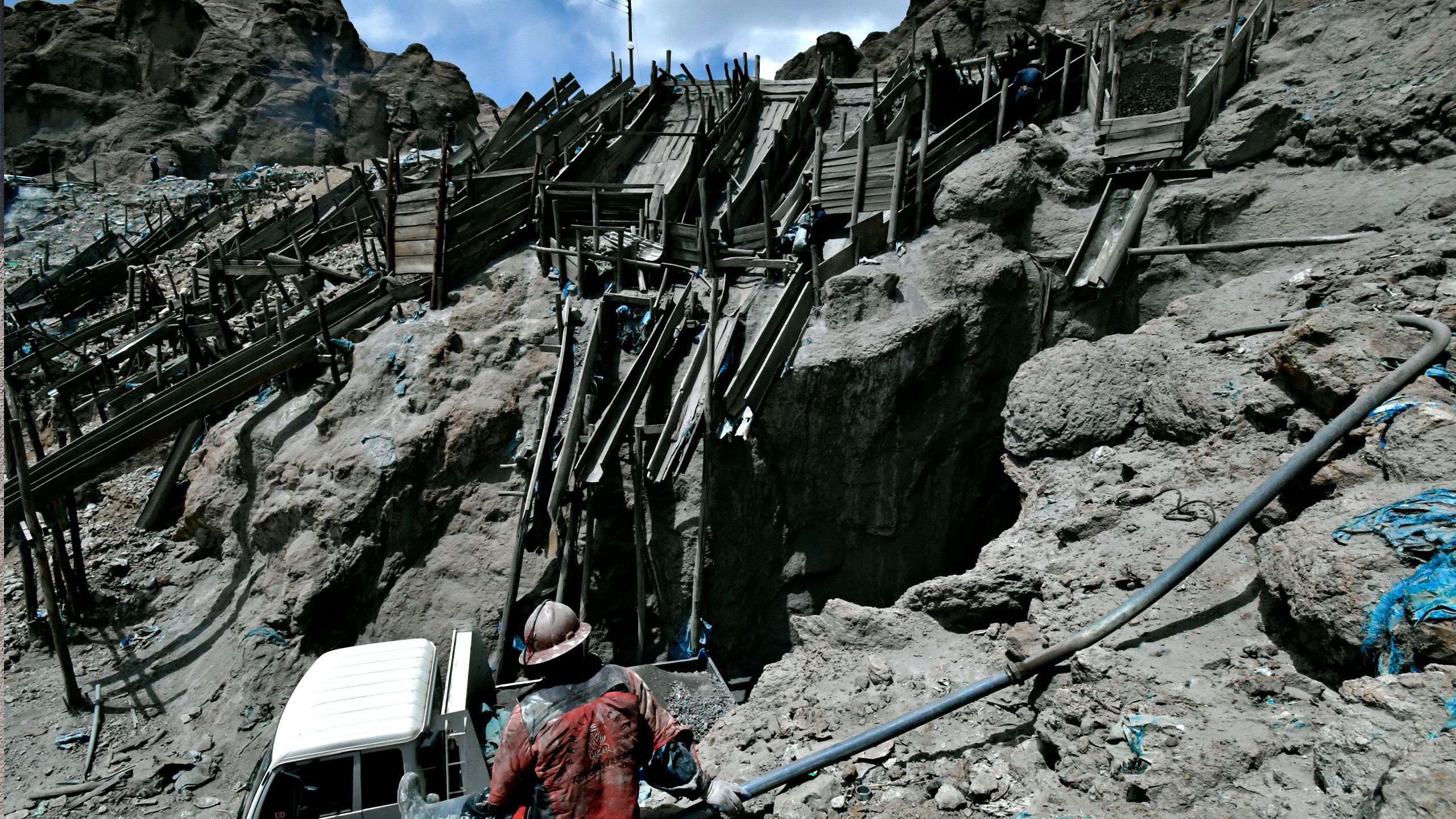 La mine est creusée dans une pente raide. Au bas de l’entrée, un camion attend d’être chargé.