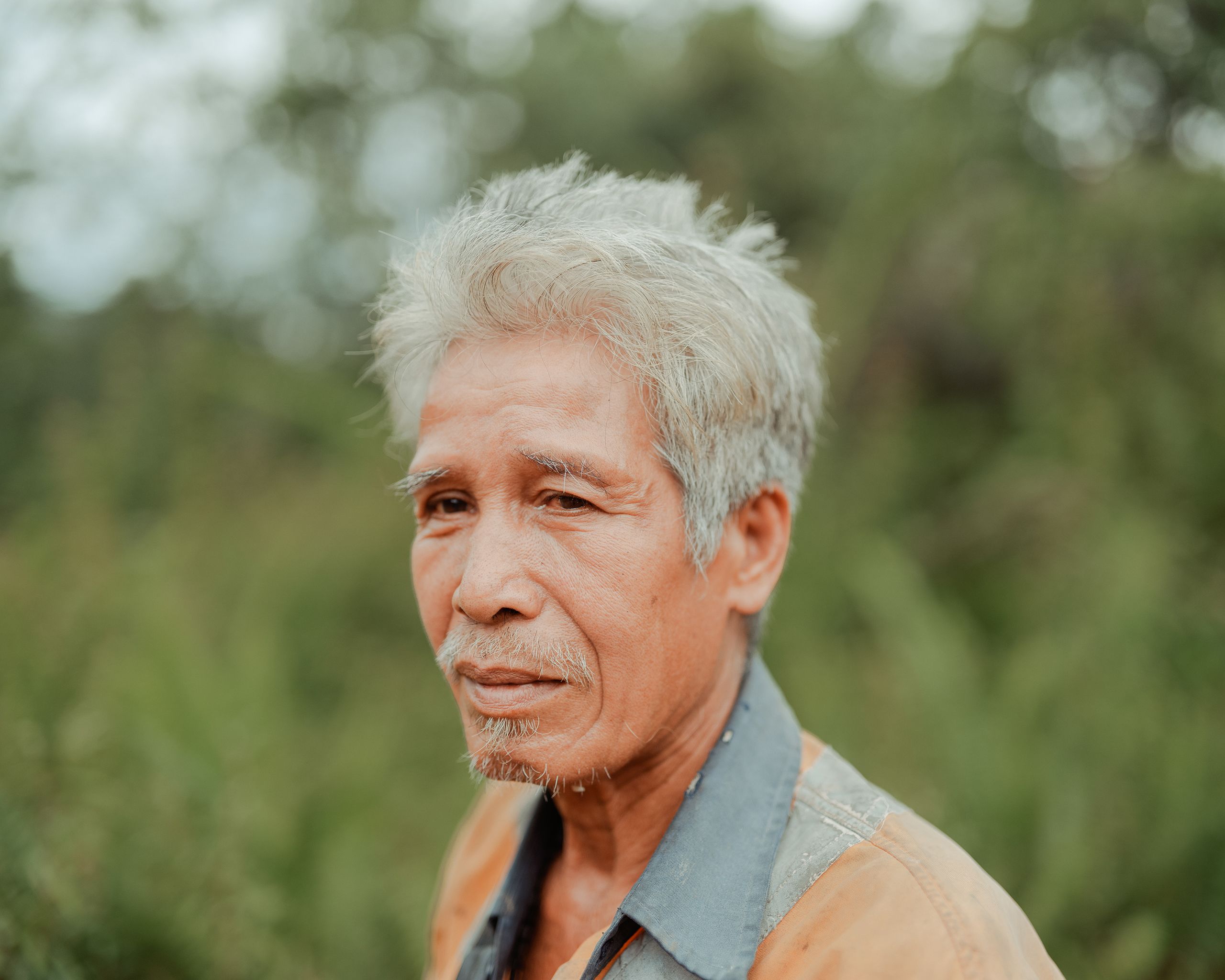 Raya porte encore un uniforme usé de Borneo Prima, l’un des deux employeurs de la région. Bien qu’il dise avoir passé “l'âge productif" selon le groupe minier, il ne désespère pas de retrouver une source de revenus.